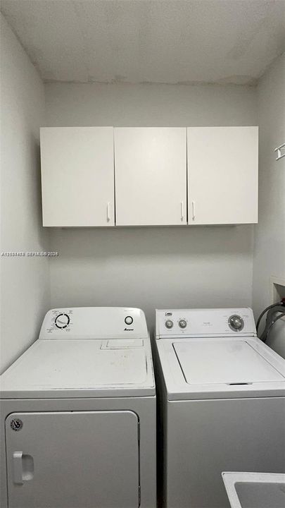 Dedicated laundry area featuring white wall-mounted cabinetry