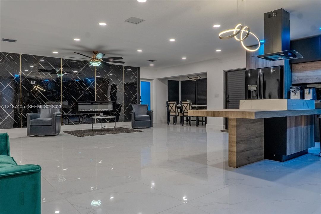 Textured dark charcoal wall paneling with a semicircular backlit mirror, wood-finish flooring, and a decorative glass panel with geometric detailing