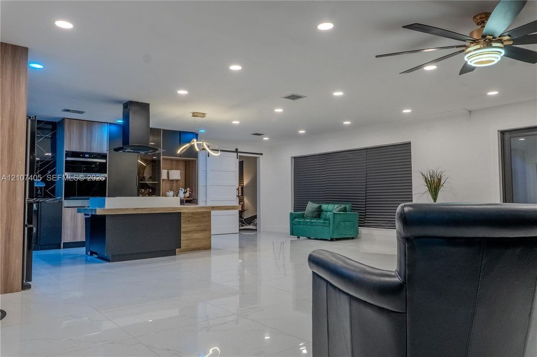 Neutral-toned room featuring wood-finish flooring, dual windows with black frames, and a ceiling-mounted fan