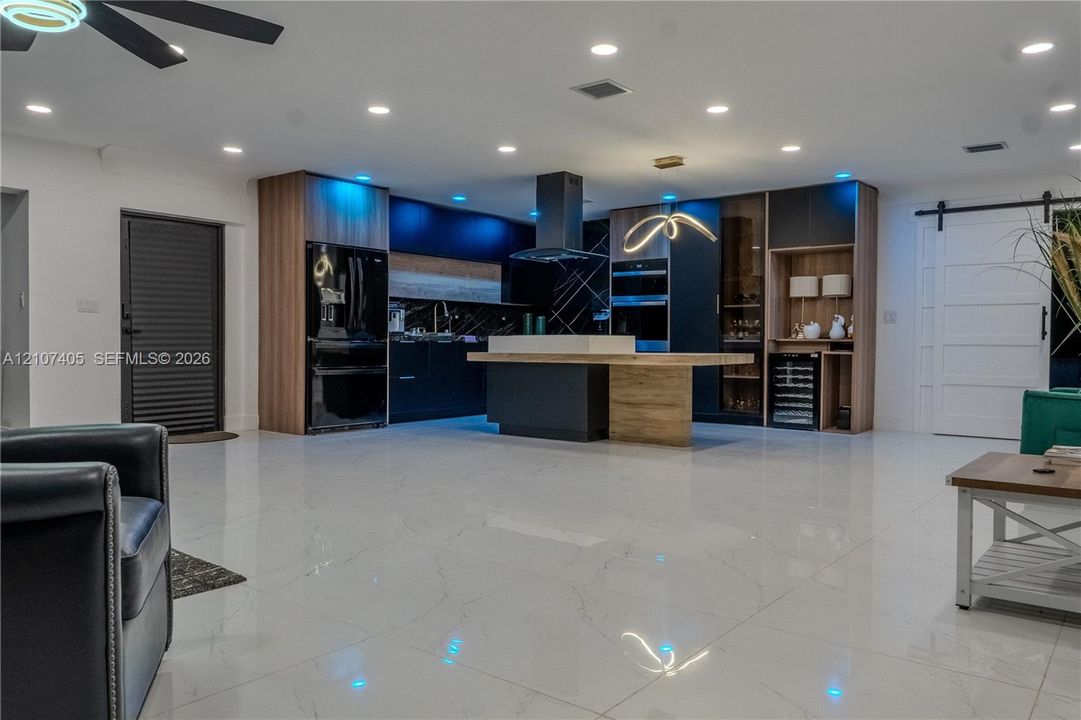 Walk-in shower with floor-to-ceiling tile surround, glass enclosure, integrated wall niche, and rainfall shower head, complemented by a floor-mounted dual-flush toilet