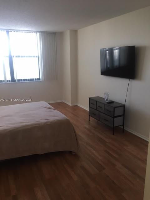 Wood-finish flooring and large-format windows with vertical blinds