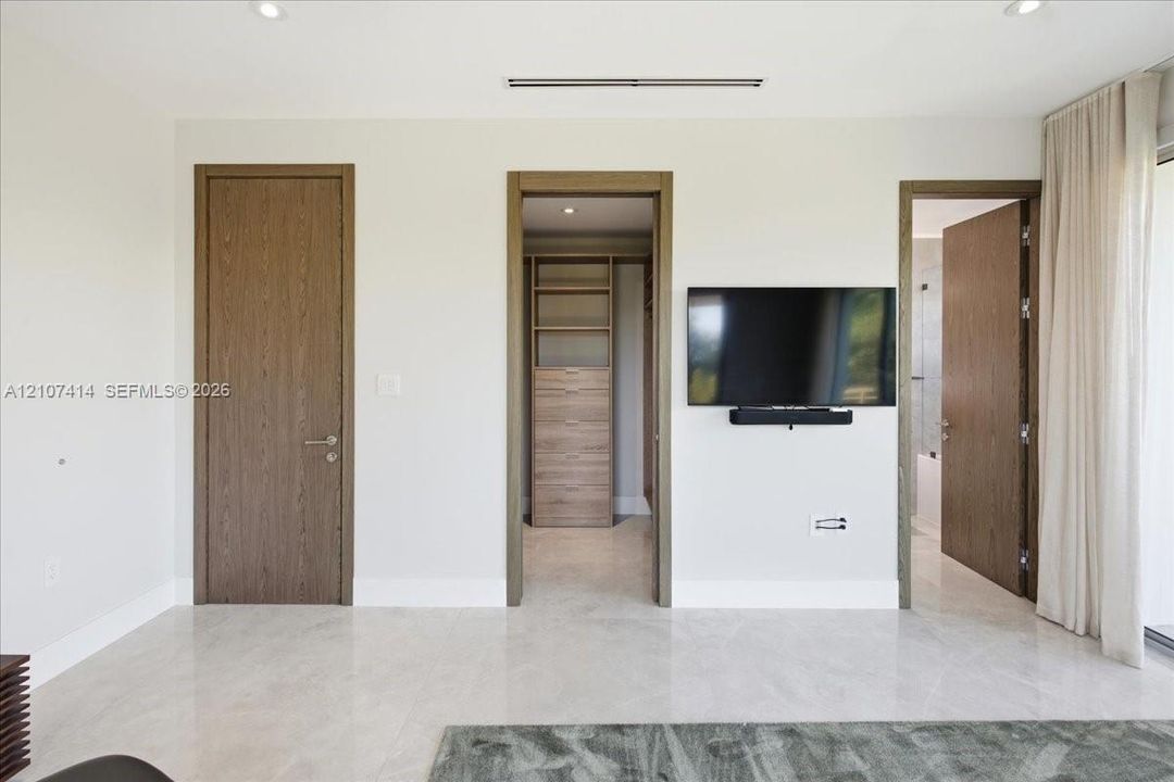 Interior space featuring large-format stone flooring, recessed lighting, and solid wood-finish doors