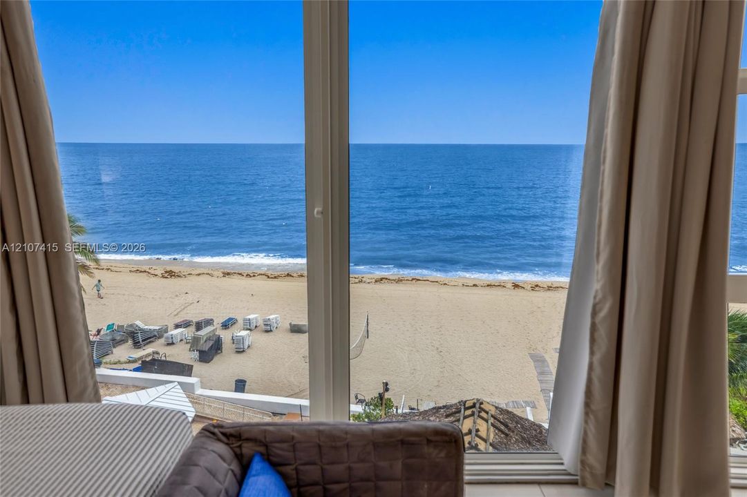 Floor-to-ceiling windows with expansive ocean, beach, and shoreline scenery