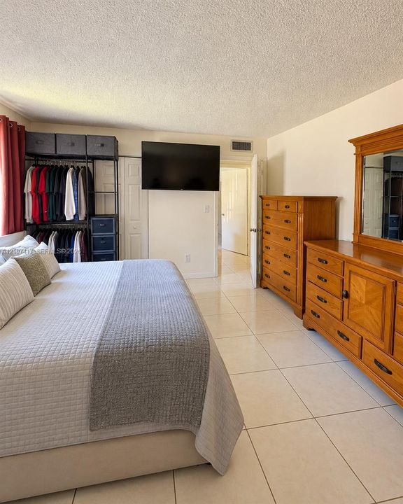 Bedroom featuring large-format ceramic tile flooring and white panel doors