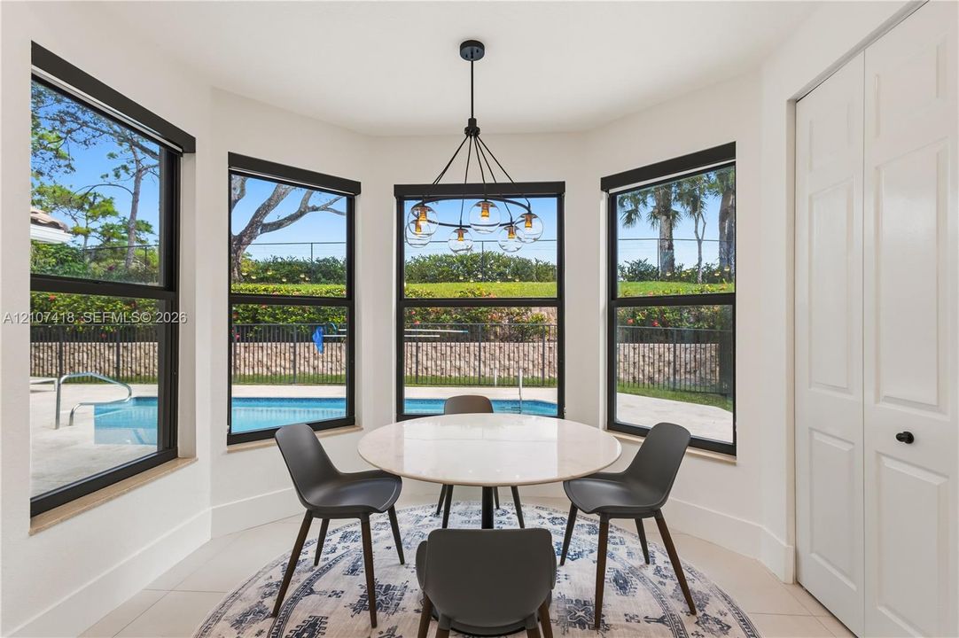 Bay window featuring floor-to-ceiling windows with black frames, tile flooring, and a multi-arm modern chandelier