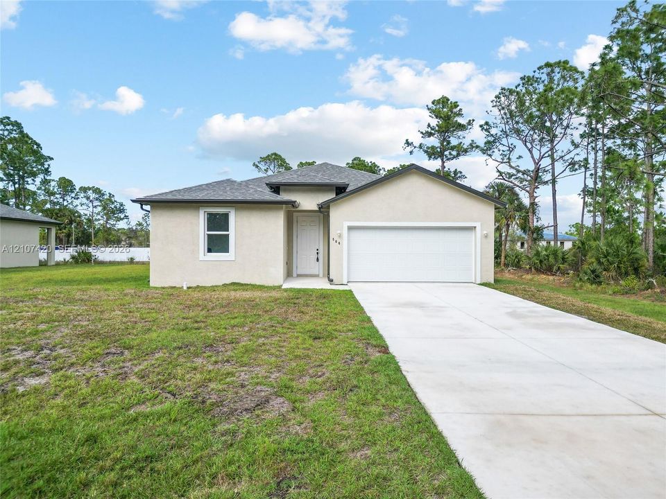 Single-story residence with a stucco exterior, asphalt shingle roof, two-car garage, and concrete driveway