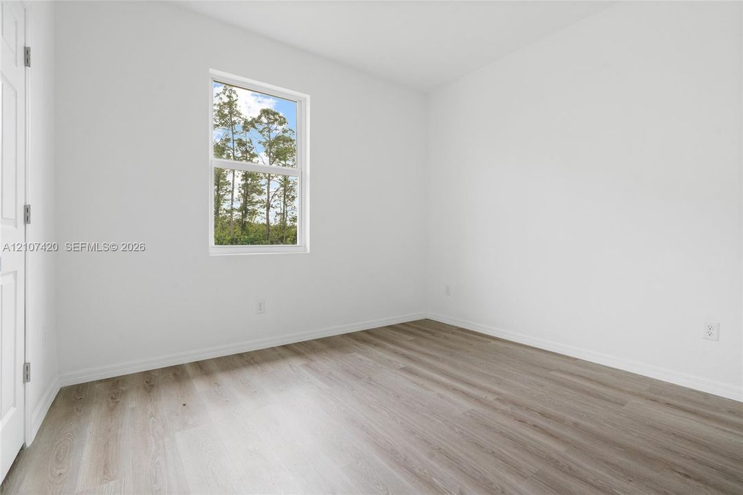 Neutral wall finishes, wood-finish flooring, and a single-hung window