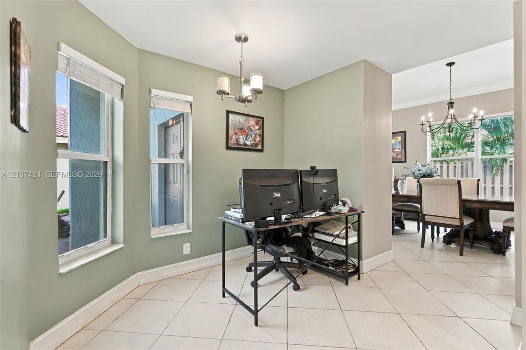 Bay window featuring multi-pane windows, large-format neutral tile flooring, and decorative chandeliers