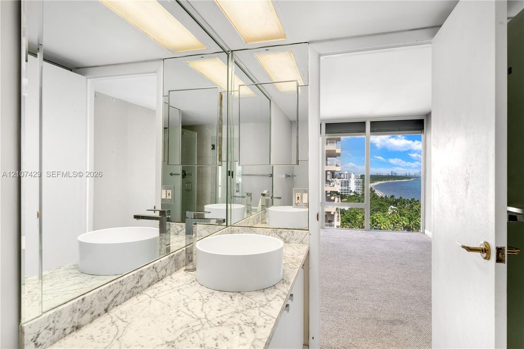 Covered balcony featuring a metal railing, concrete flooring, and an overhead flush-mount light fixture