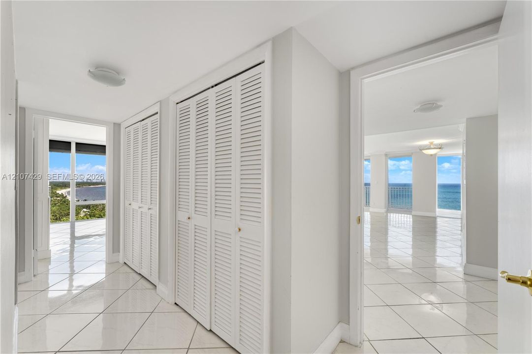 Private balcony featuring tile flooring and a metal railing, providing an elevated outlook of the coastline and surrounding landscape