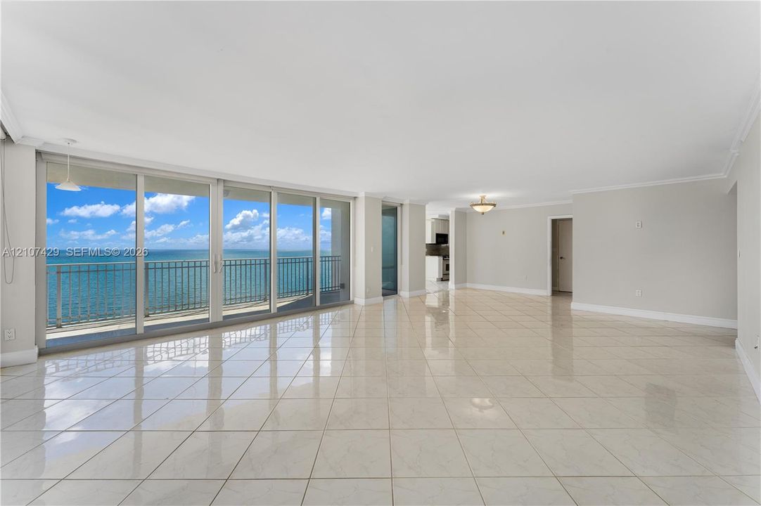 White shaker-style cabinetry, stone countertops with matching full-height backsplash, undermount sink with arched faucet, stainless steel appliances, and recessed ceiling lighting