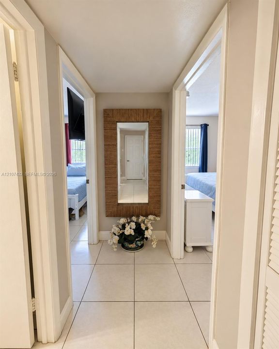 Neutral-toned ceramic tile flooring, solid-core interior doors, and crisp white door casing