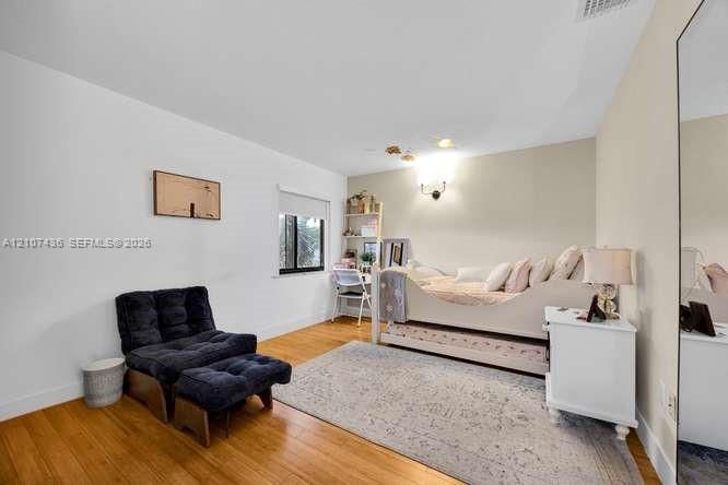 Neutral wall tones, wood-finish flooring, and a large wall-mounted mirror