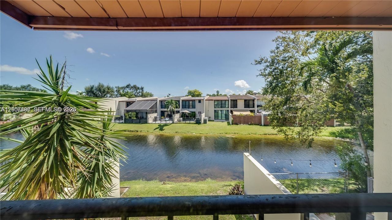 Waterfront balcony featuring a metal railing and an overhead wood-plank ceiling