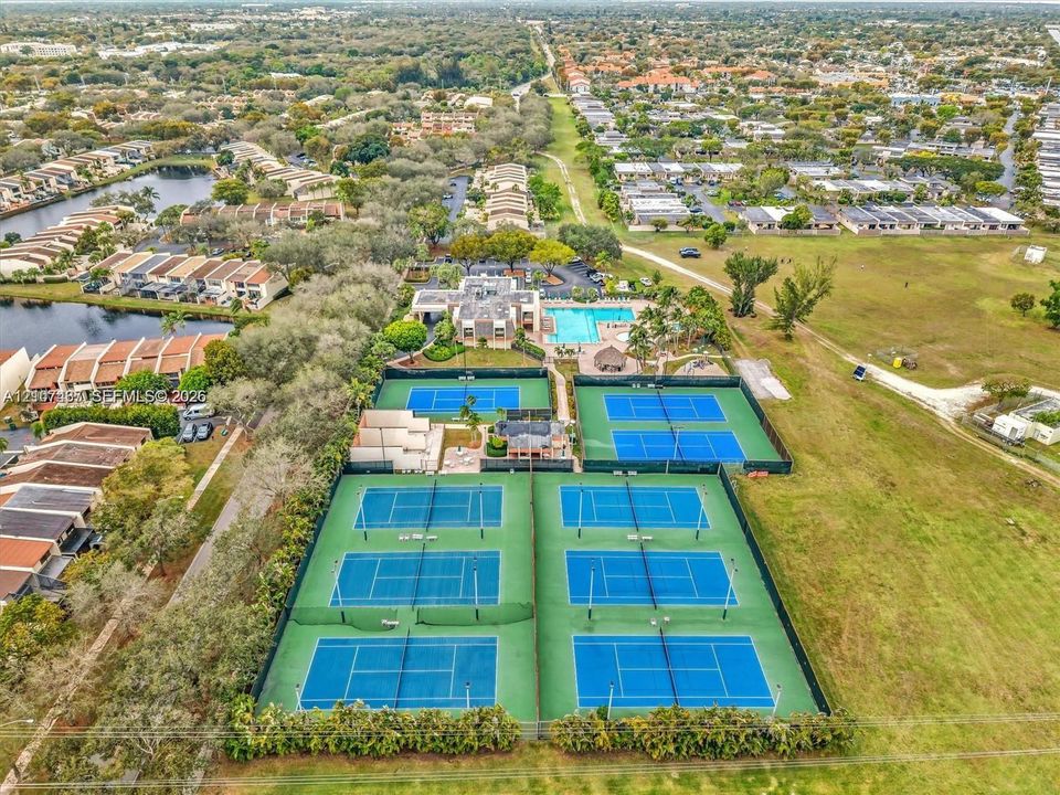 Aerial view featuring a multi-court tennis complex and an outdoor swimming pool facility