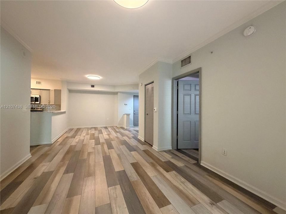 Interior space featuring multi-tonal wood-finish flooring, recessed ceiling lighting, and crown molding