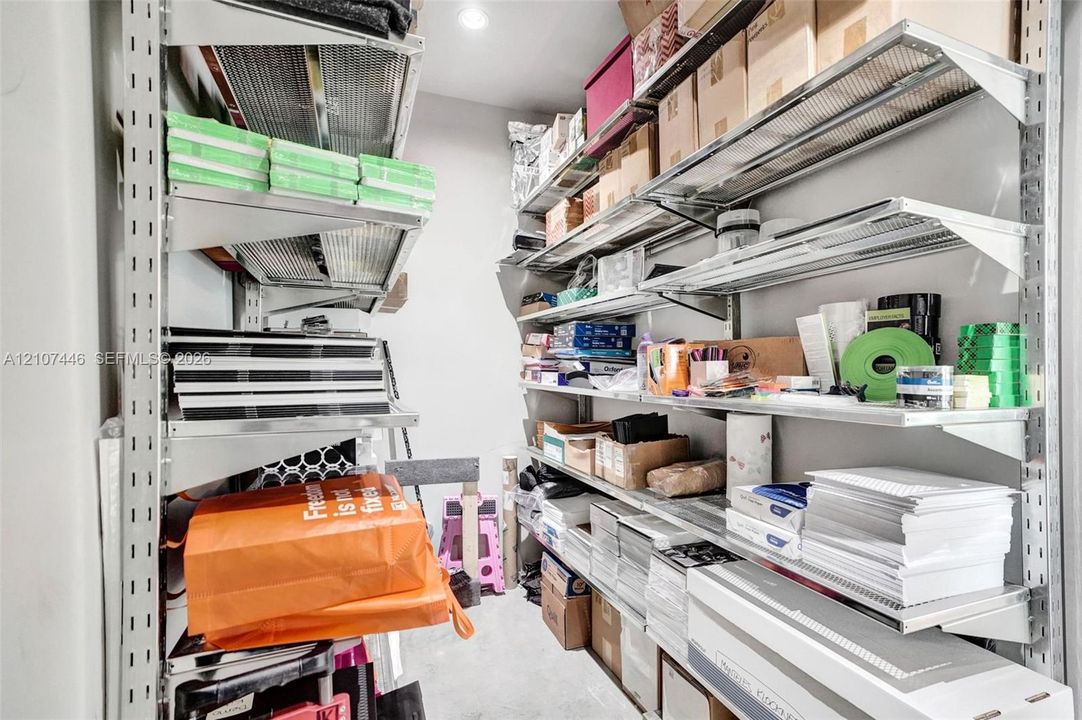 Storage area featuring wall-mounted industrial metal shelving units with adjustable rack positioning and recessed lighting