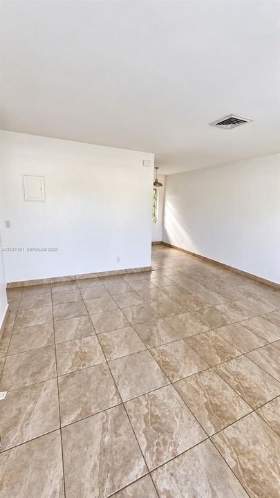 Open-concept interior space featuring large-format ceramic tile flooring with stone-pattern detail and neutral wall finishes