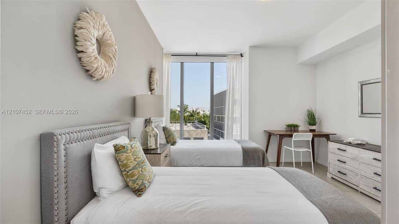 Floor-to-ceiling windows with natural light, neutral interior wall palette, and light-toned hard-surface flooring