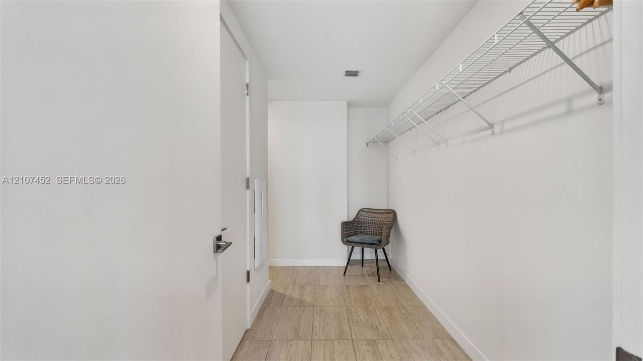 Walk-in closet featuring wood-finish flooring and wall-mounted wire shelving