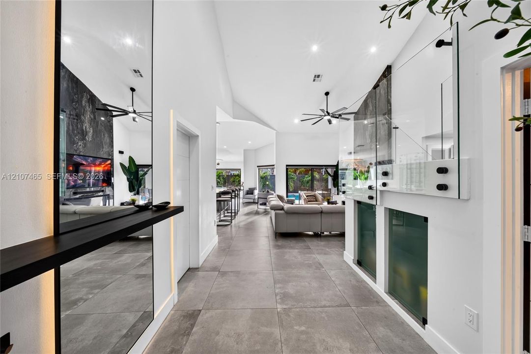 Vaulted ceilings, large-format tile flooring, integrated wall lighting, floor-to-ceiling mirrors, and architectural glass partitioning