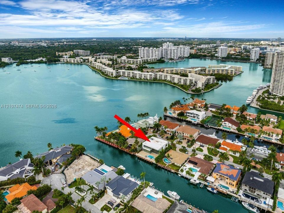 Waterfront property featuring deep-water canal access, a private swimming pool, concrete seawall, and multi-level terrace