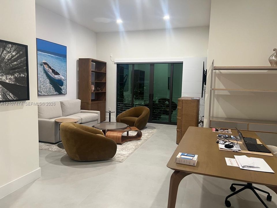 Large format tile flooring, recessed lighting, and expansive floor-to-ceiling sliding glass doors