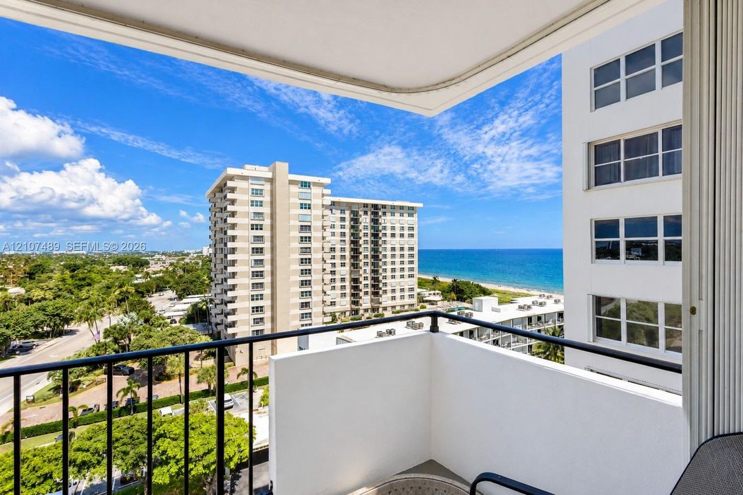 Private balcony with black metal railing overlooking the oceanfront and coastal landscape