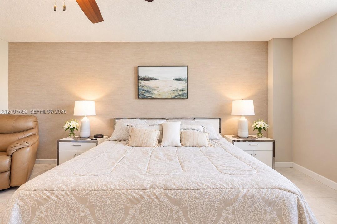Textured accent wall featuring a neutral finish and ceiling-mounted fan