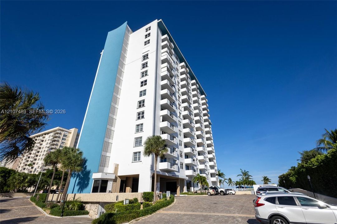 High-rise building featuring a blue accent facade, white exterior finish, and uniform private balconies