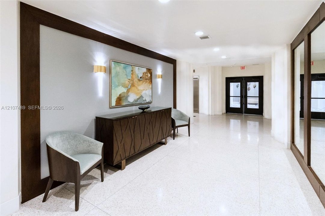 Polished stone flooring, custom wood trim architectural detailing, recessed ceiling lighting, and wall-mounted sconces
