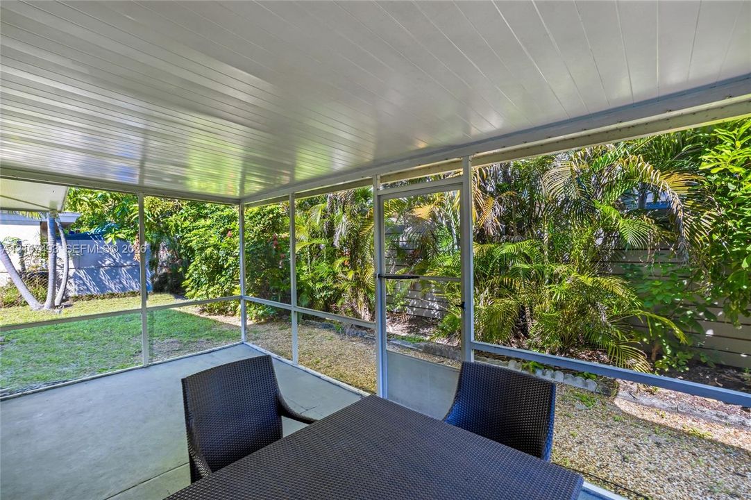 Main Apt, West side, Screened-in patio featuring a concrete floor, white tongue-and-groove ceiling, and a full-height screen enclosure