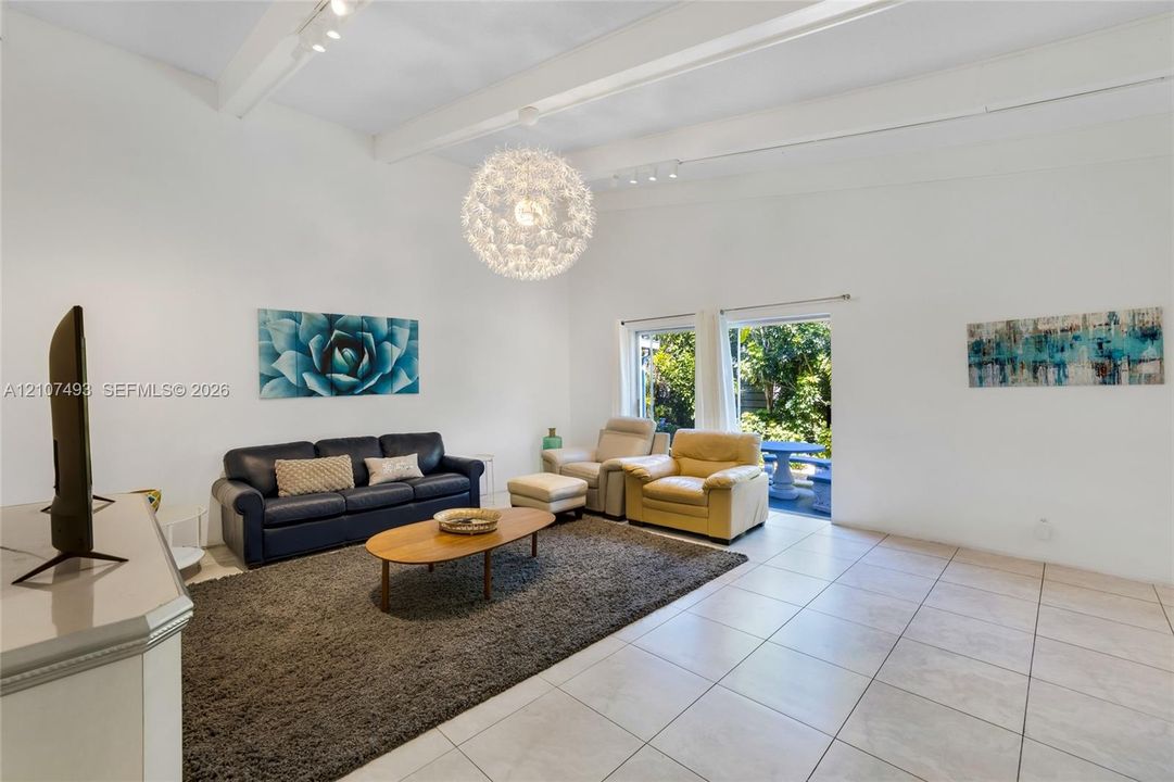 Main Apt, East side, Vaulted ceilings with exposed structural beams, tile flooring, and a large spherical pendant light fixture