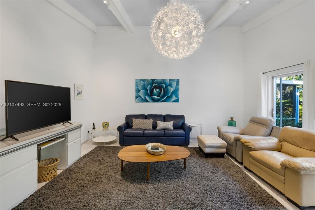 Main Apt, East side, High vaulted ceilings featuring exposed structural beams, a statement spherical pendant light fixture, and floor-to-ceiling glass sliding doors