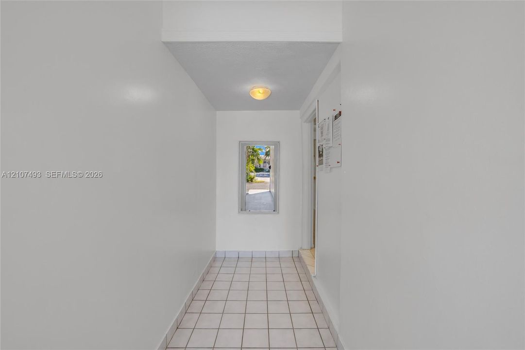 Main Apt , East side, Hallway Entrance, Interior hall featuring white tile flooring, neutral wall finishes, and a flush-mount light fixture