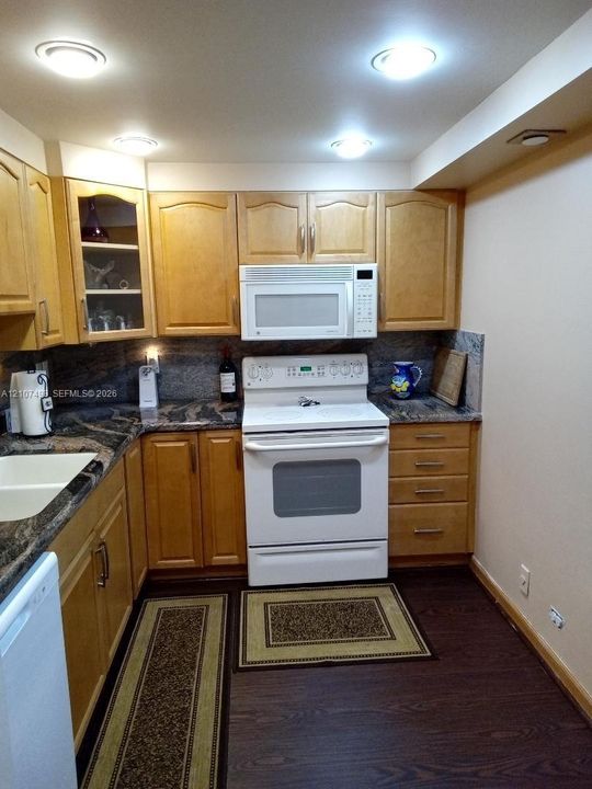 Kitchen featuring light-finish cabinetry, stone-patterned countertops, a white range with over-the-range microwave, recessed lighting, and dark-finish flooring
