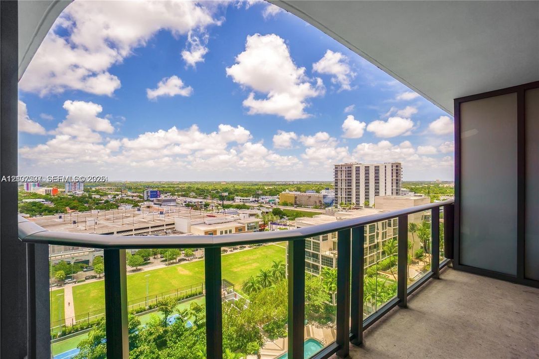 Covered balcony featuring concrete flooring and a dark metal railing