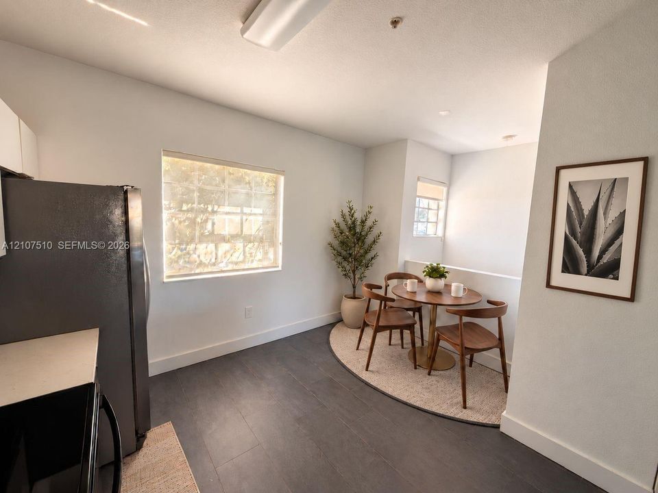 Wood-finish flooring, dual windows with roller shades, and integrated kitchen cabinetry