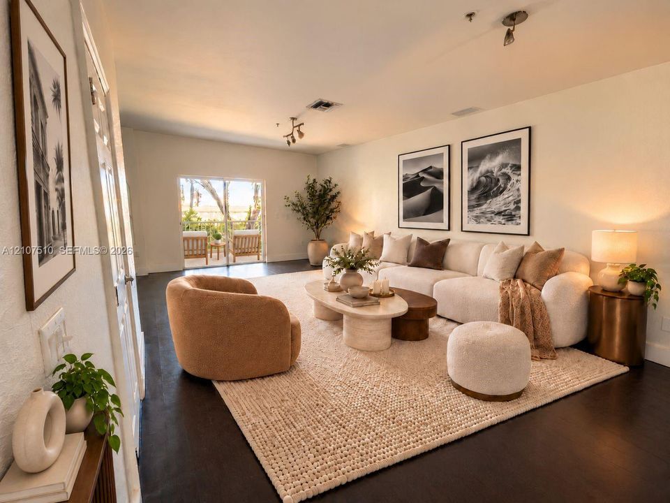 Living space featuring dark wood-finish flooring, neutral wall tones, multi-directional ceiling-mounted lighting, and sliding glass doors providing outdoor access