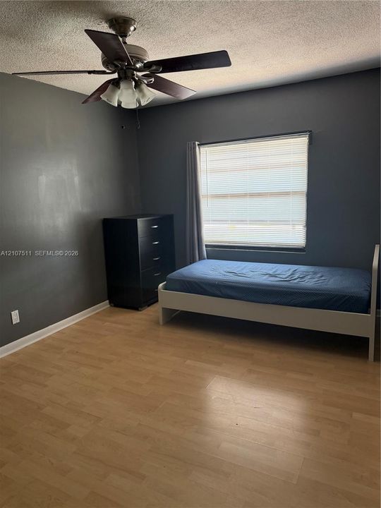 Wood-finish flooring, ceiling fan with integrated light fixture, and horizontal window blinds