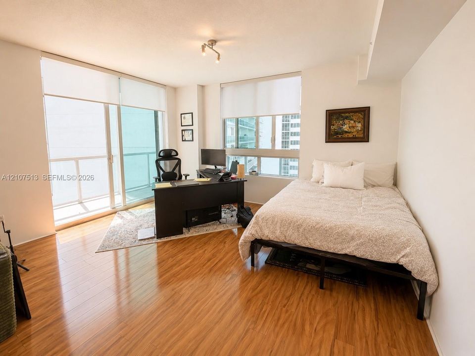 Wood-finish flooring, floor-to-ceiling windows, sliding glass door, and a private balcony