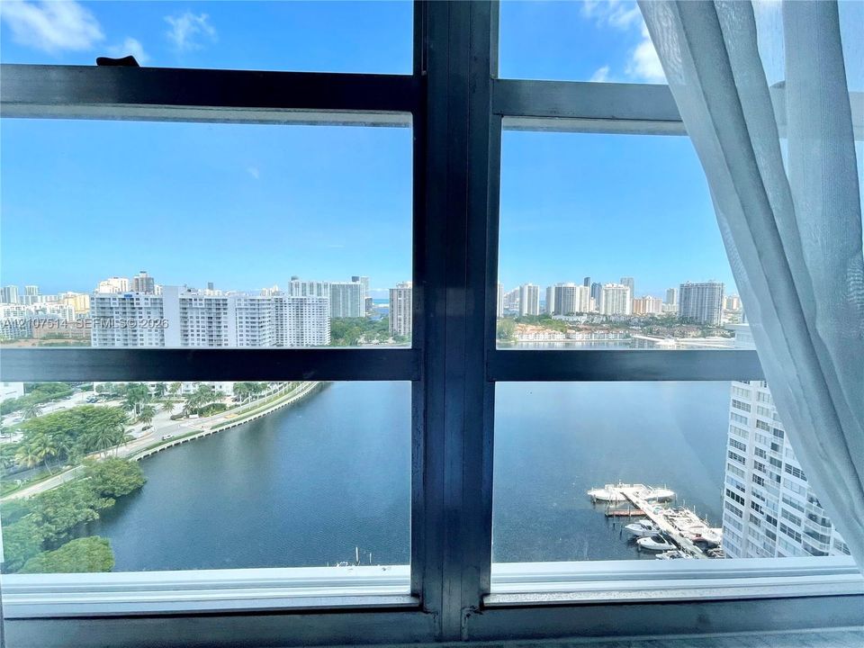 Large-format metal-framed windows featuring expansive water and urban skyline scenery