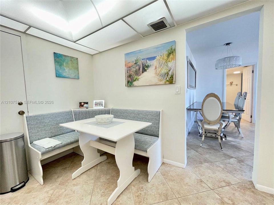 Built-in corner bench seating with neutral upholstery and tile flooring