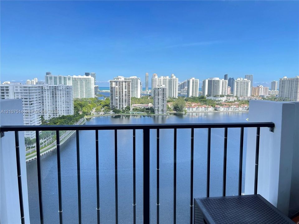Balcony featuring a black metal railing and panoramic water and city skyline scenery