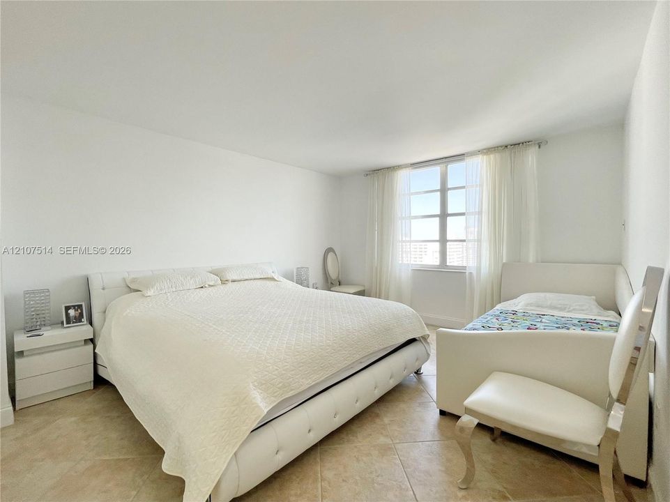 Room featuring neutral walls, large multi-pane windows, and light-toned tile flooring