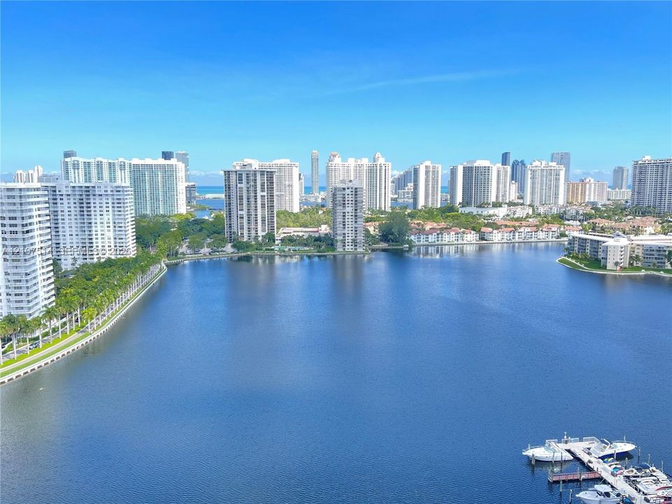 Panoramic water expanse with a private boat dock and surrounding coastal high-rise development