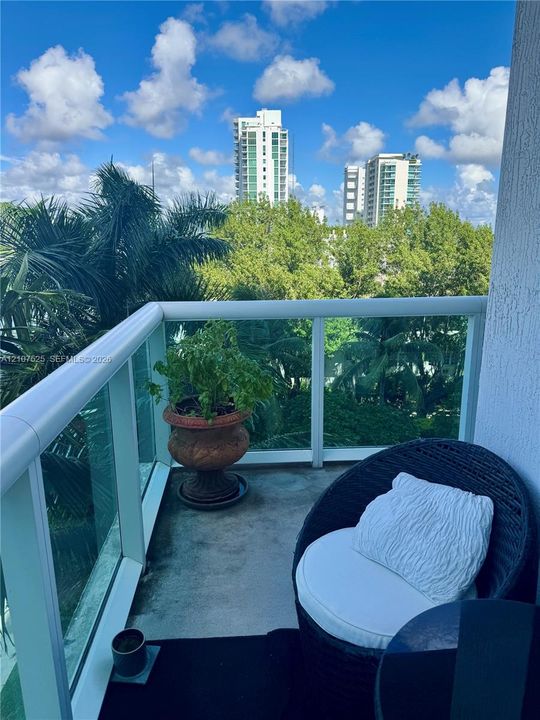 Private balcony featuring glass panel railings and a concrete surface