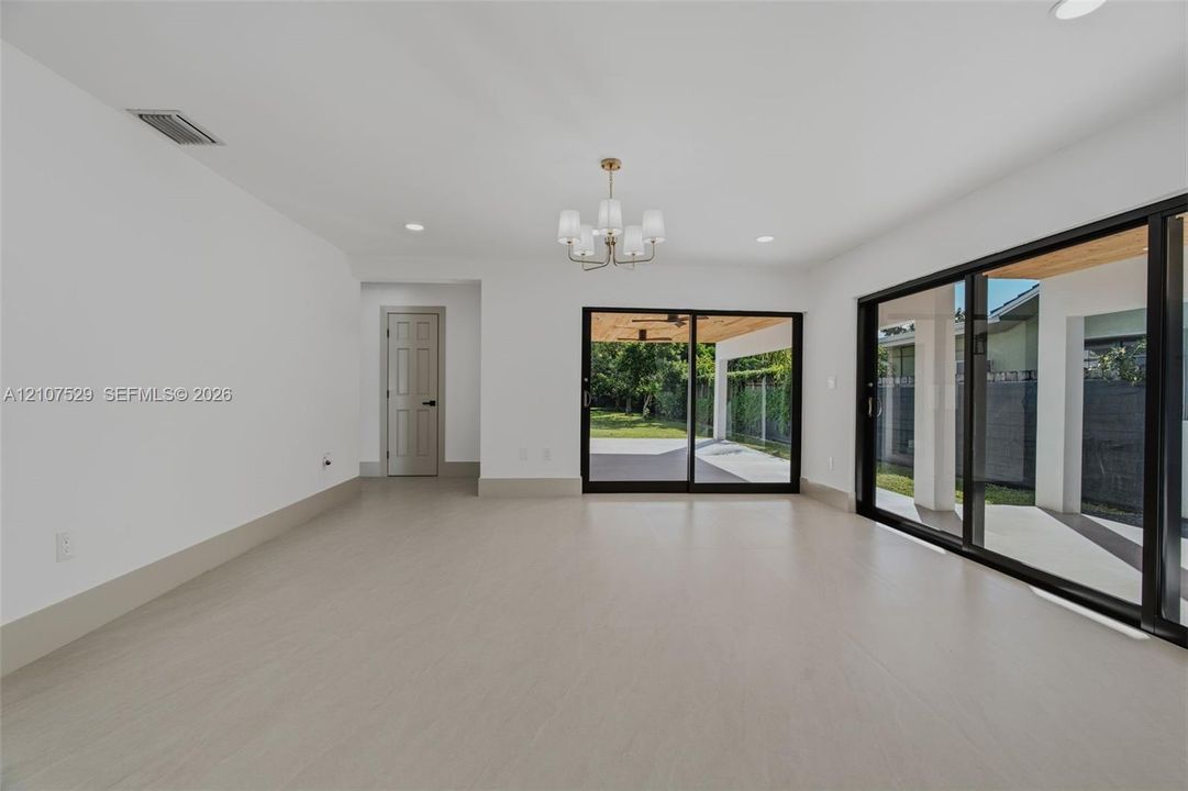 Covered patio featuring a wood-plank ceiling, large-format tile flooring, recessed lighting, ceiling fans, and sliding glass doors