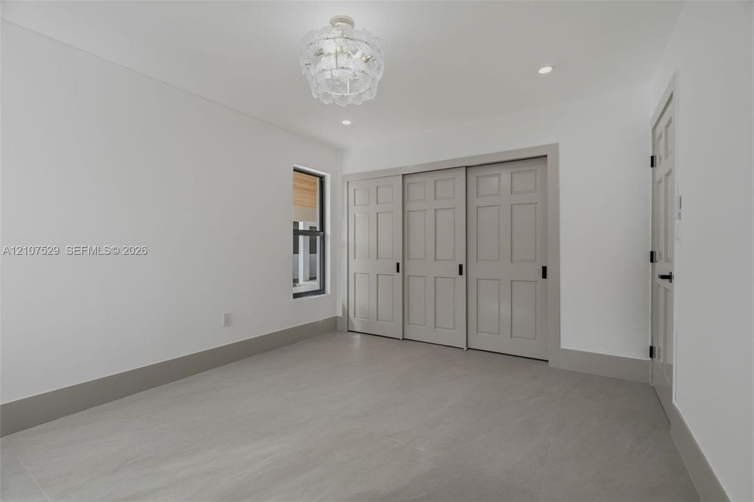 Expansive backyard featuring a large grass lawn, mature trees, and privacy fencing