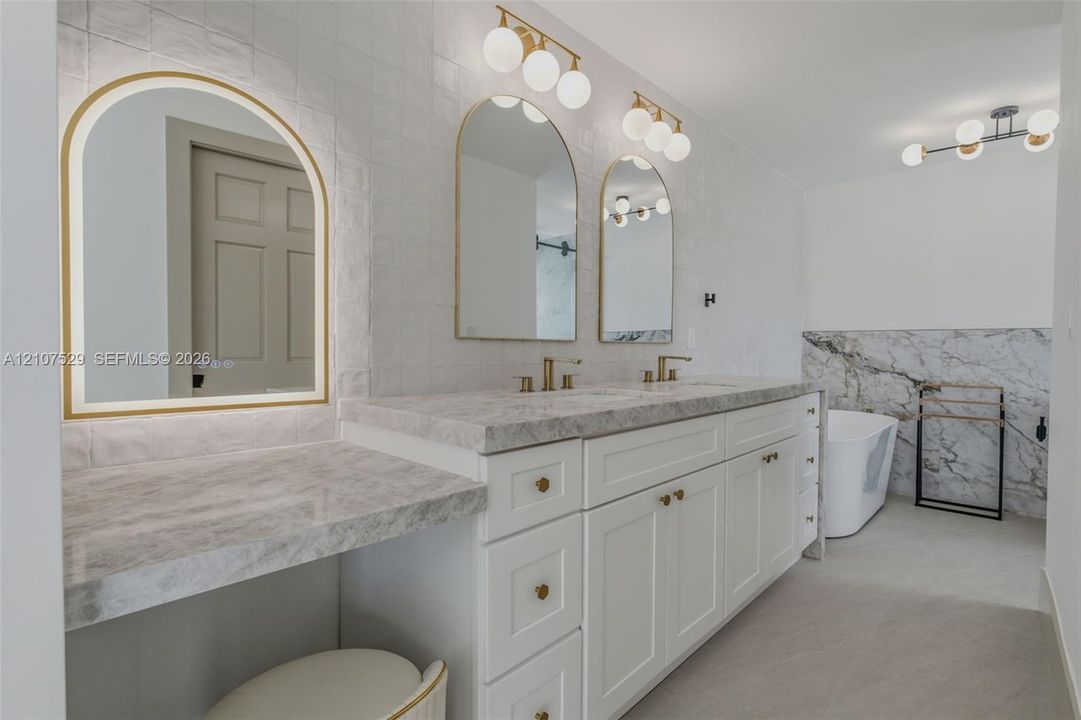 Covered patio featuring large-format porcelain tile flooring and smooth white stucco exterior wall finishes